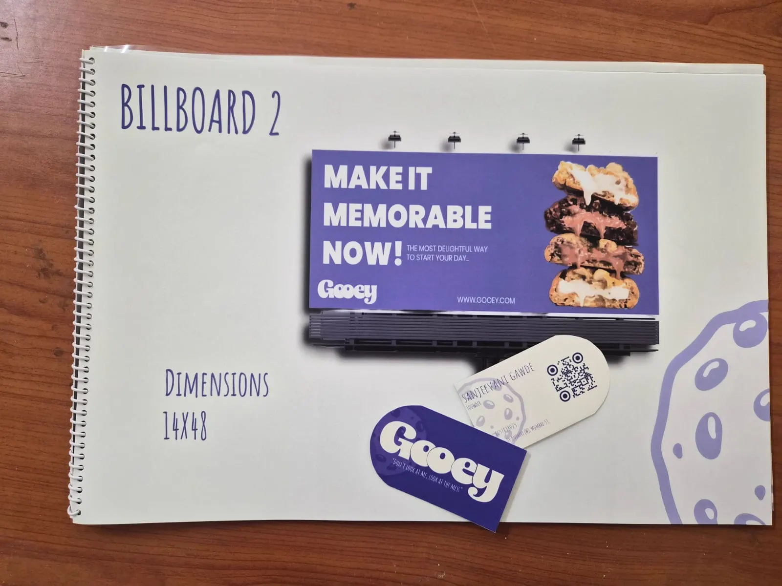 Student business studies coursework portfolio showing a billboard mock-up, logo and business card design